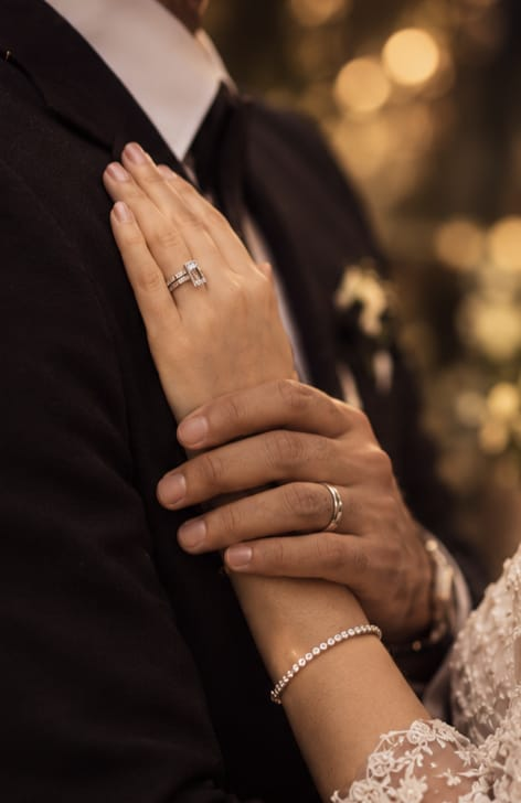 Hands with wedding rings resting over the heart